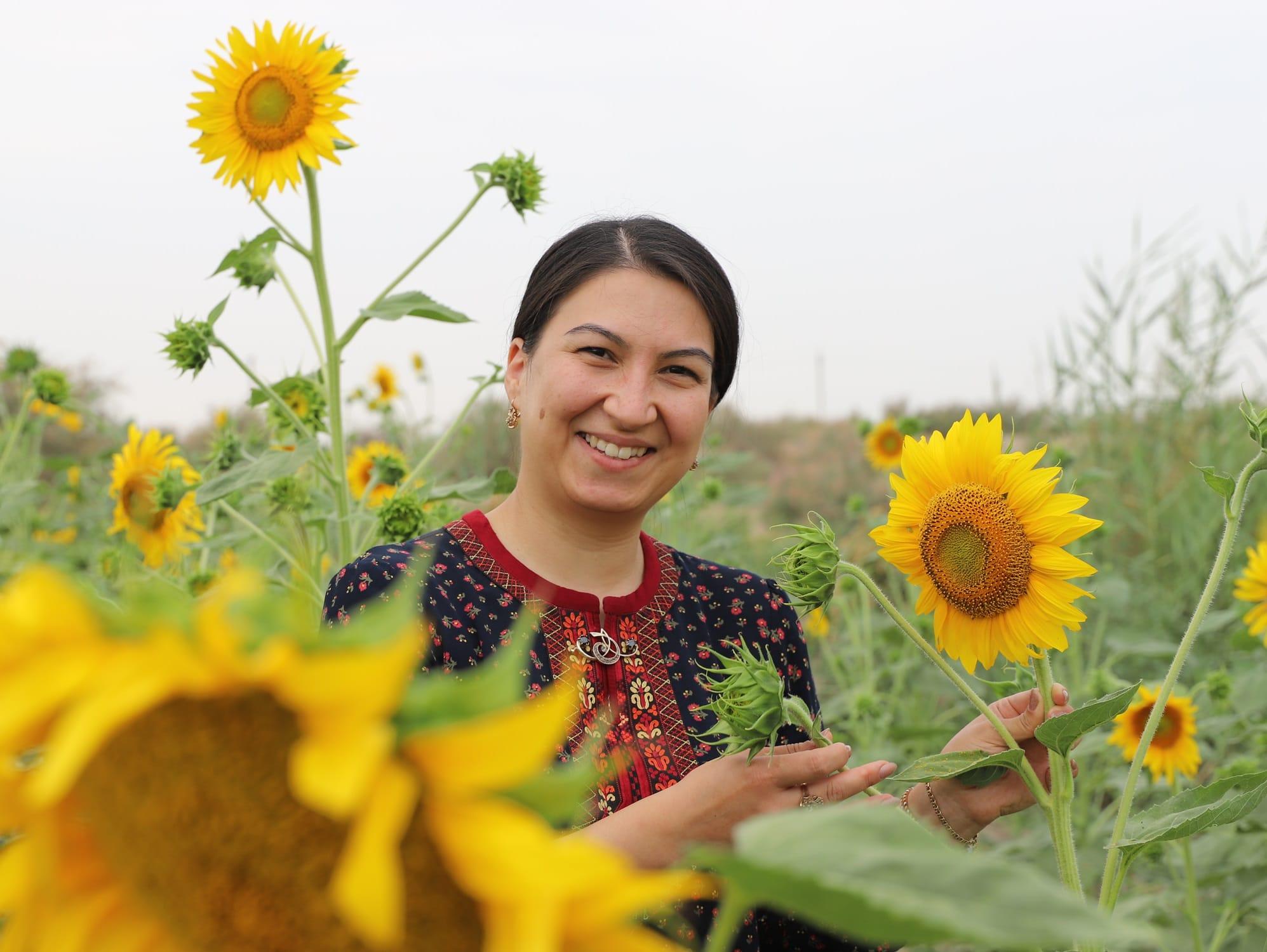 Woman standing amongst sunflowers
